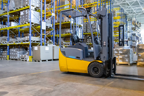 Carretilla elevadora frontal parada en almacén 