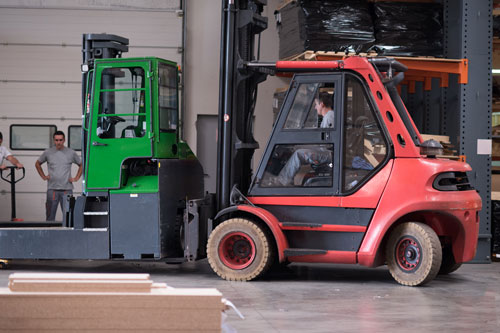 Operario carretillero cargando maquina para trasladarla